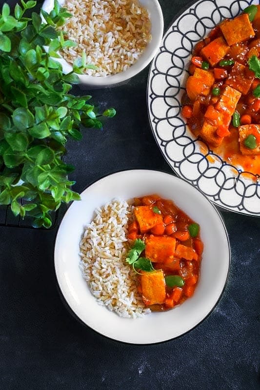 Sweet and Sour Tofu with steamed rice in a bowl