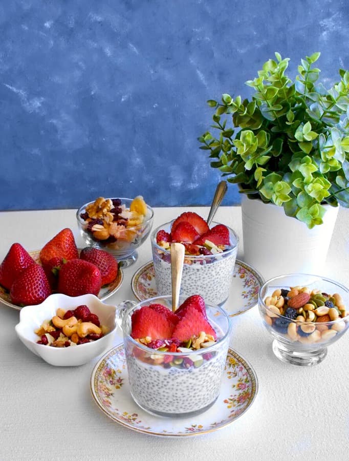 Vegan Coconut Chia Pudding in cups topped with strawberries and nuts