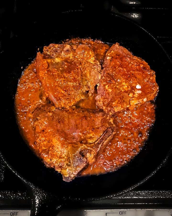 Indian lamb chops being cooked in a skillet