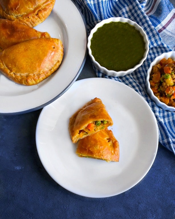 baked lamb curry puffs in a white plate with chutney