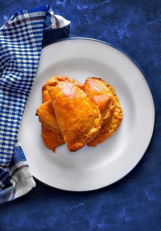 indian lamb curry puffs in a white plate and blue napkin