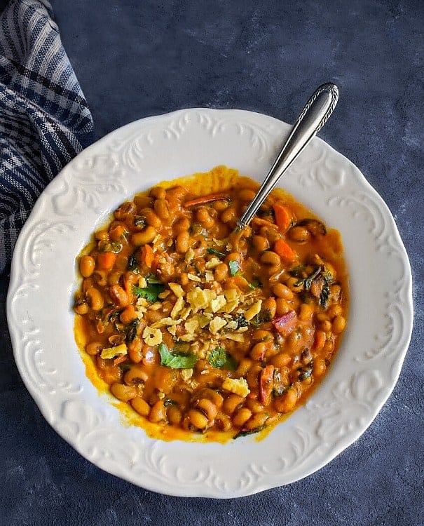 instant pot black eyed peas in a white bowl with chips on top