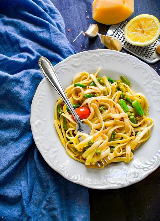 Lemon Asparagus Pasta with Peas in a white plate and blue napkin