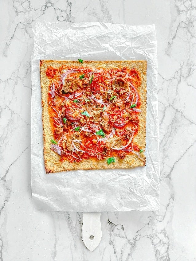 spicy meat lovers garlic pizza on a white marble board