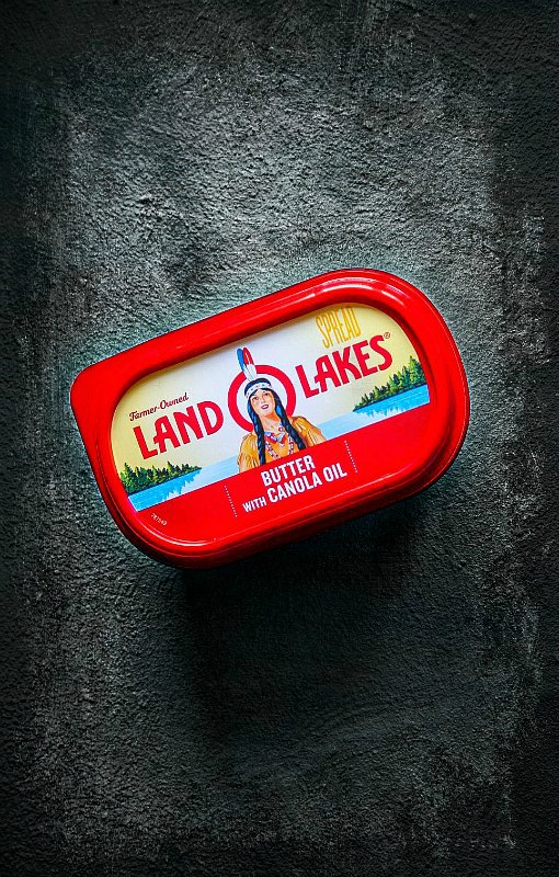 land-o-lakes butter with canola oil on a black-white rusted background