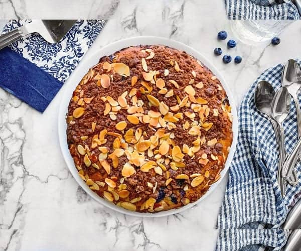 Moist Almond Blueberry Coffee Cake on a plate with blue napkins